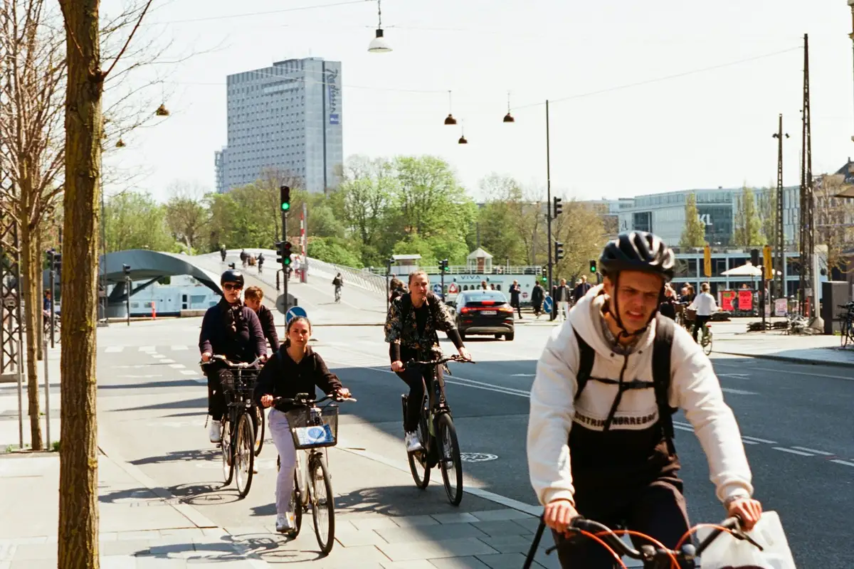 Personas desplazándose en bicicleta por un carril bici urbano camino del trabajo