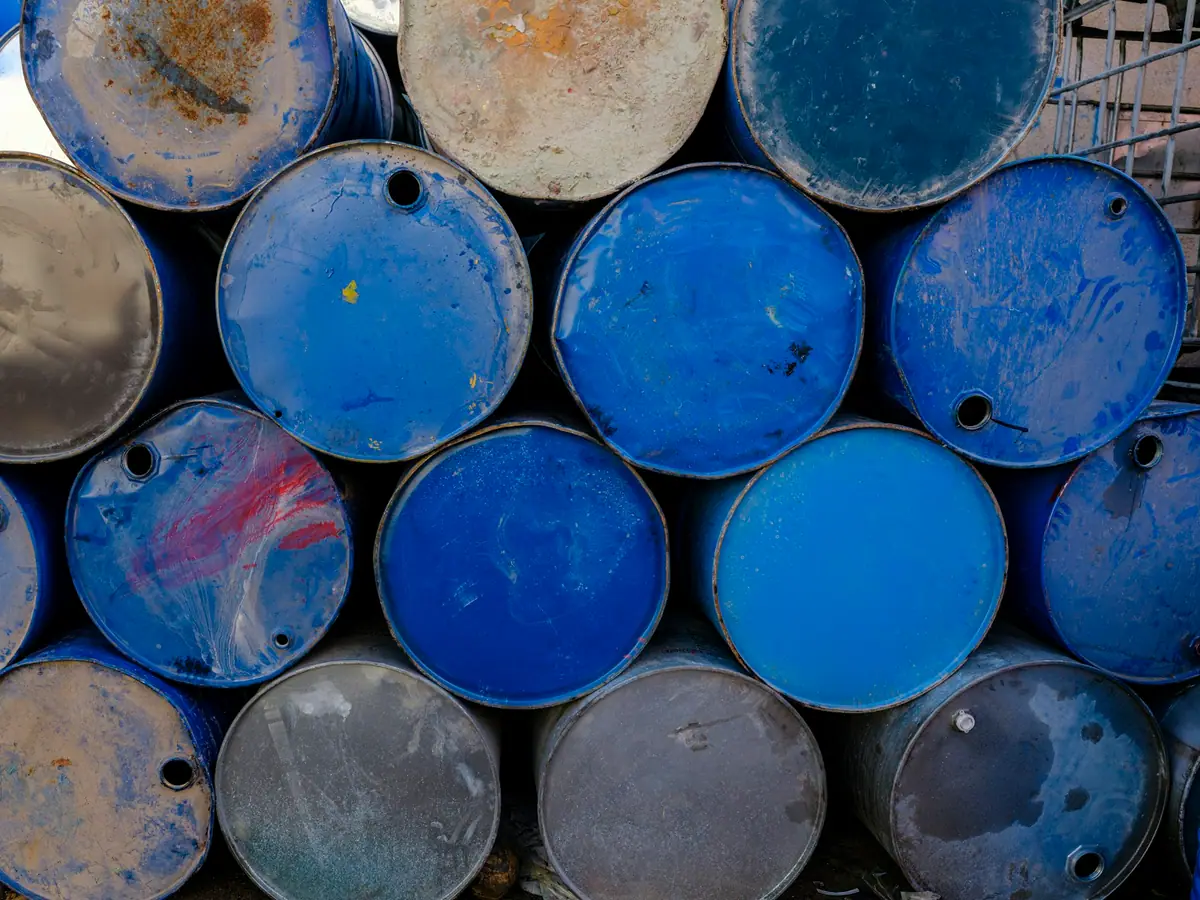 Bidones industriales apilados en una nave de fabricación y almacenamiento de lubricantes