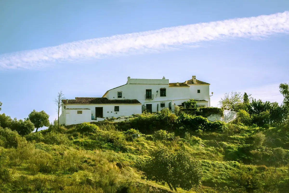Cortijo blanco en una ladera, edificio rural adecuado como albergue municipal