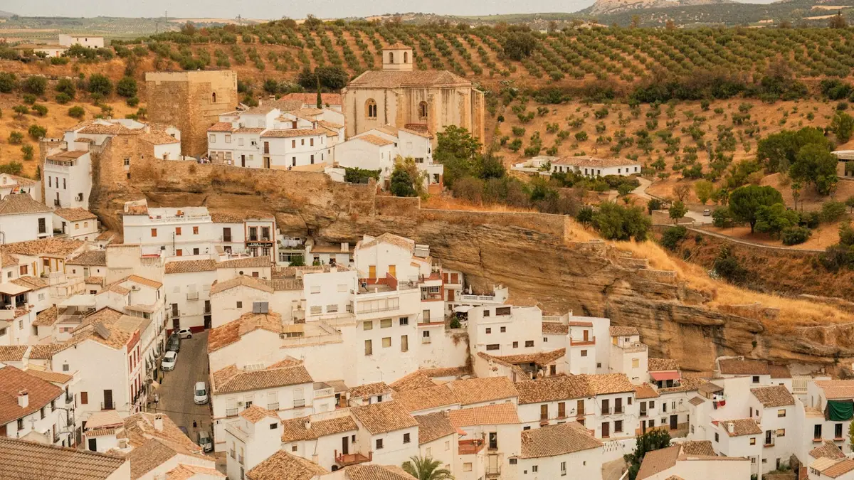 Pueblo blanco andaluz sobre una colina con olivares, ámbito típico de un plan de ordenación urbana municipal
